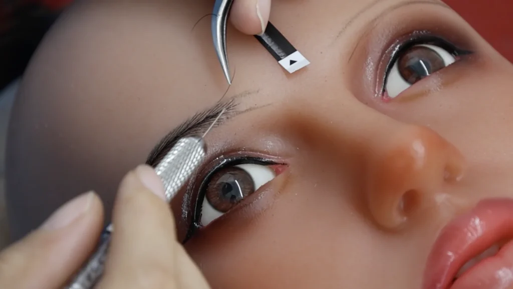 Handcrafted eyebrow detailing during realistic sex doll makeup process